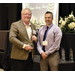 Two Gentlemen standing together, one holding an award