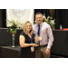 A woman holding an award presented by a man