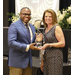 A gentleman accepting an award handed to him by a woman 