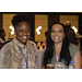 Two women sit smiling at a camera