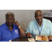 Two people sitting at a table smiling for the camera