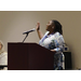 A woman speaking at a podium gesturing with her hands