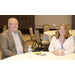 A man and a woman sitting at a table together smiling and looking at the camera