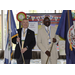 two men standing together holding flags smiling at the camera