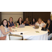 A group of women sitting at a table smiling at the camera