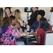 a group of ladies sitting at a table chatting and snacking