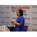A woman speaking in front of a step and repeat backdrop branded for Columbia Housing