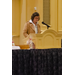 A woman wearing glasses speaks at the podium.