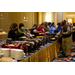 Catering dishes full of food line the table as people fill their plates.