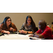 Two women look at the man sitting to their left.