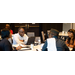 Two men and two women sit at a table talking to each other.