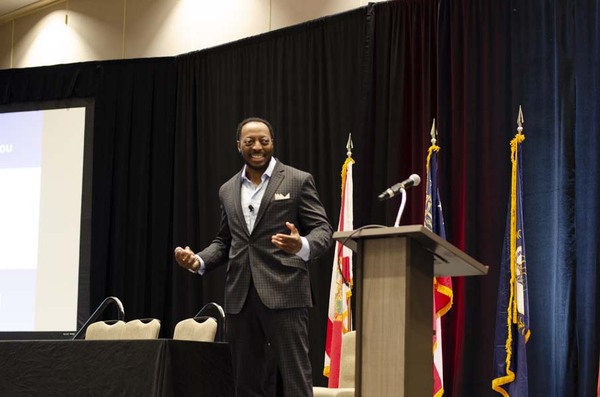 Opening Speaker Mike Howard standing on stage smiling