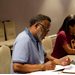 Executive Director Mark C. Reid sitting at a table writing