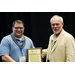 Two men holding an award and smiling