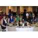 Five people sitting around a table wearing masks