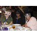 Three women sitting at a table and wearing masks 