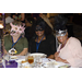 Three women sitting at a table and wearing masks
