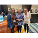 Three women with name tags posing together. 