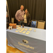 A man and a woman hug behind a table for a company called Gallagher.