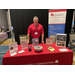 A man standing behind a booth for Quadel Consulting.