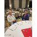 An older man and woman smile at a table.