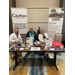 Two men and a woman smile while sitting at the Cauthen and Associates Booth. 