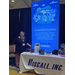 A woman stands next to the booth table for Hiscall Inc. 