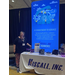 A woman stands next to the booth table for Hiscall Inc.