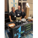 Two women and a man stand behind the Radon 1 table. 