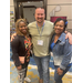 A man poses between two women for a photo. 