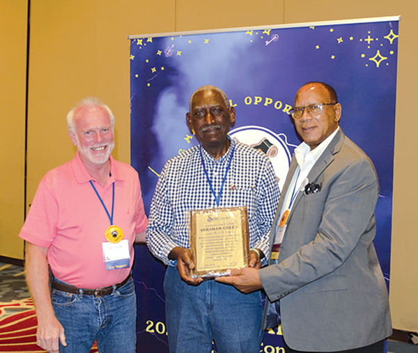 Three men holding an award.