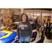 A woman standing next to a race car.