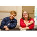 Two ladies sitting together and smiling.