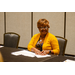  woman sitting down wearing a yellow cardigan.