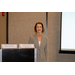 A woman standing by a projector screen.