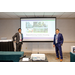 Two men standing by a projector screen giving a presentation.