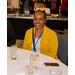 A woman wearing yellow sitting at a table.