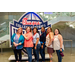  Lineup of six women at the Executive Committee dinner in front of a Chick-fil-a sponsored College Football Hall of Fame sign. 