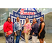  Lineup of five women at the Executive Committee dinner in front of a Chick-fil-a sponsored College Football Hall of Fame sign. 