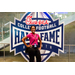  Woman in a pink shirt at the Executive Committee dinner in front of a Chick-fil-a sponsored College Football Hall of Fame sign. 