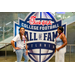  Two ladies at the Executive Committee dinner in front of a Chick-fil-a sponsored College Football Hall of Fame sign. 