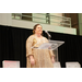  A woman stands and speaks at the podium. 