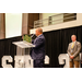  A man speaking at the podium holding up a plaque that says SERC-NAHRO, In Honor of Abraham A. Williams Jr. 