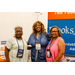  Kimberly and Joyce smile with another woman in front of the Brooks Jeffrey banner. 
