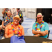  Two men wearing hats and leis sitting at a table. 