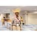  A man with a pink lei wearing a straw hat. 