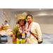  A woman wearing two leis and a hula skirt standing next to a woman wearing one lei. 