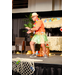  A man in an orange shirt and a green grass skirt getting ready to stomp and clap. 