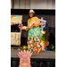  A woman in a hula shirt and hat smiling as she dances. 