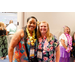  Two woman in Hawaiian shirts smiling big for the camera. 
